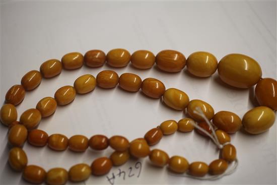 A single strand graduated oval amber bead necklace, 72cm.